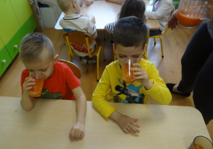 Chłopcy piją sok marchwiowy